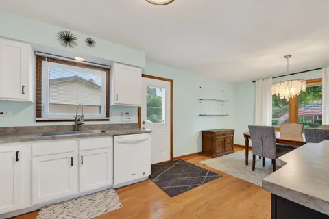 a en suite bathroom with a granite countertop sink and a large mirror