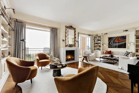 a living room with fireplace furniture and a large window