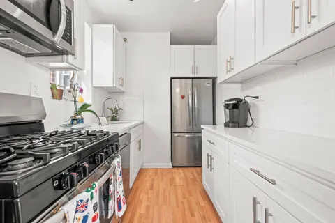 a kitchen with stainless steel appliances a stove a sink and a refrigerator