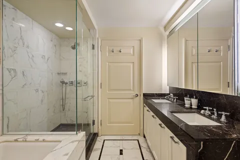 a bathroom with a granite countertop sink a toilet a mirror and shower