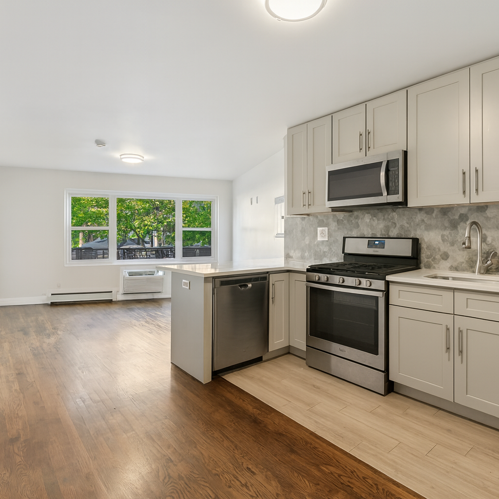 189 Woodpoint Road Brooklyn, NY 11211 - Photo 4 of 21 a kitchen with stainless steel appliances granite countertop a stove a sink and a microwave