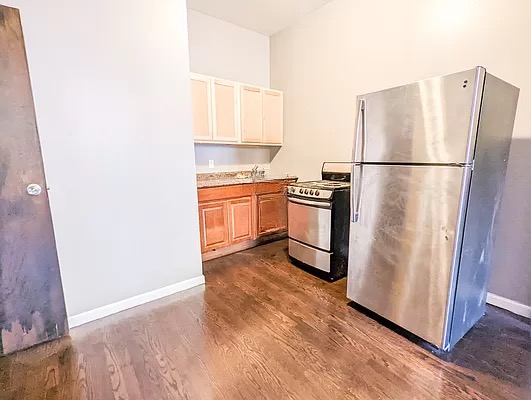 448 Hancock Street, Unit 2 Brooklyn, NY 11233 - Photo 2 of 5 a kitchen with stainless steel appliances granite countertop a refrigerator sink and stove