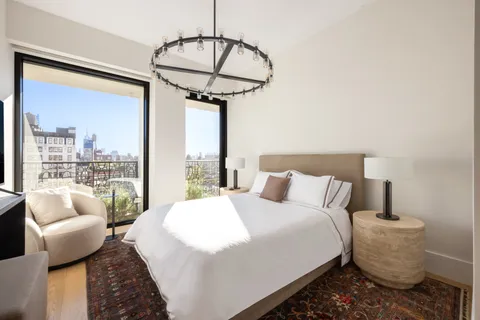 a bedroom with a bed and a chandelier