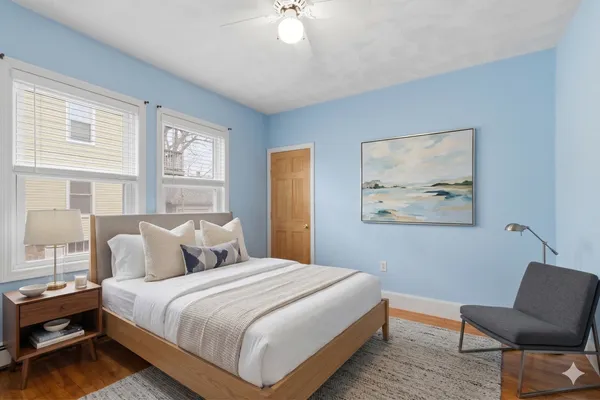 a bedroom with a bed and chair with window
