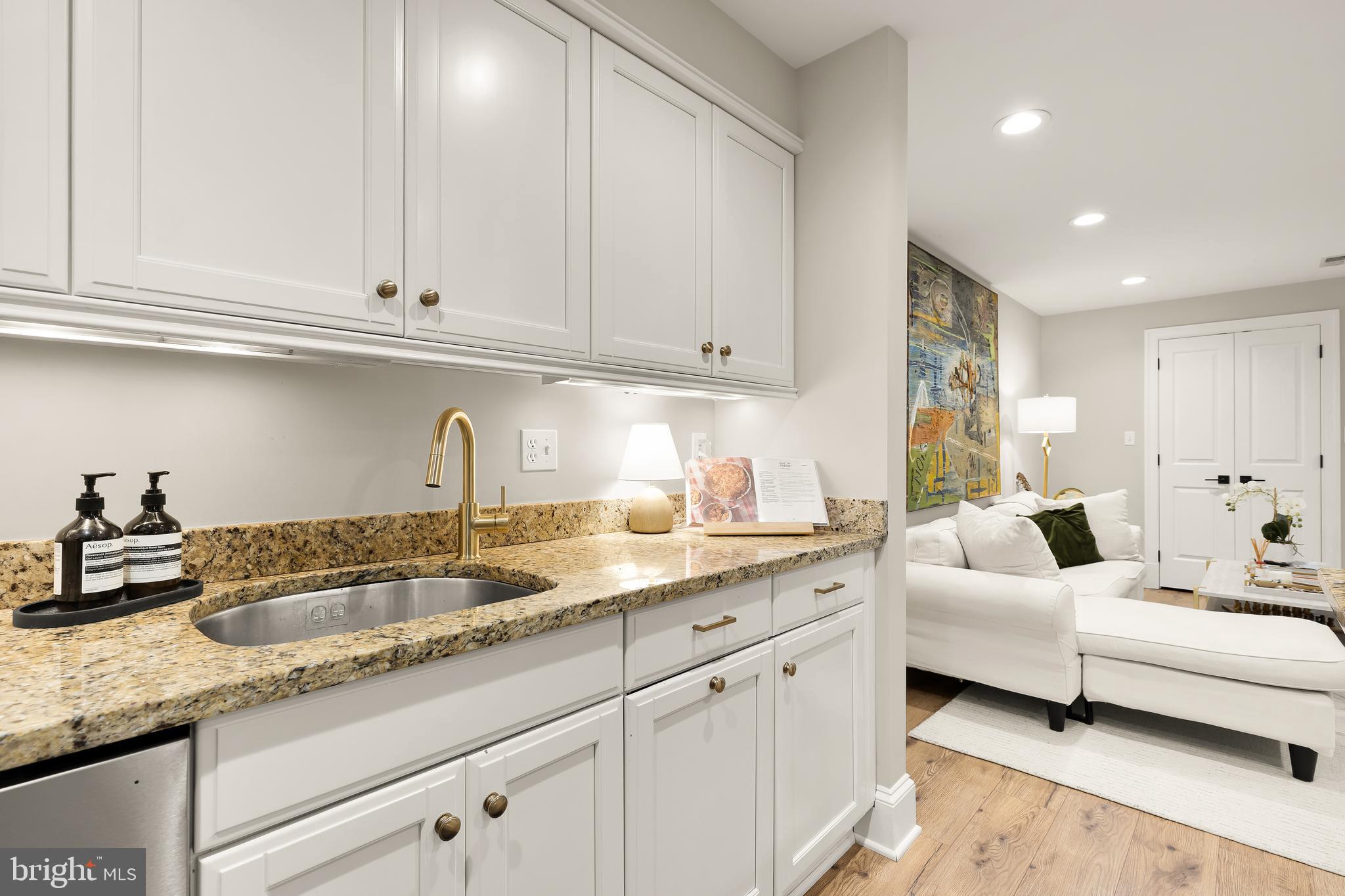 1354 Kenyon Street Northwest, Unit G Washington, DC 20010 - Photo 15 of 37 a kitchen with granite countertop white cabinets and sink