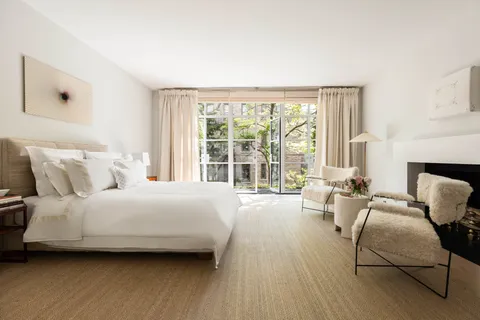 a bed sitting in a bedroom next to a window