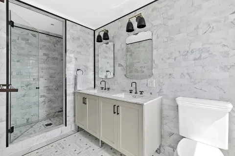 a bathroom with a shower sink mirror and toilet