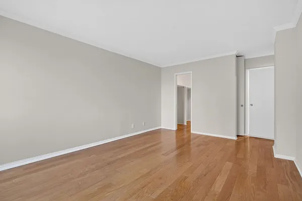 a view of an empty room with wooden floor