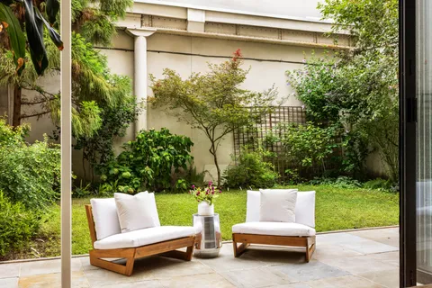 a view of a bench in the back yard of a house