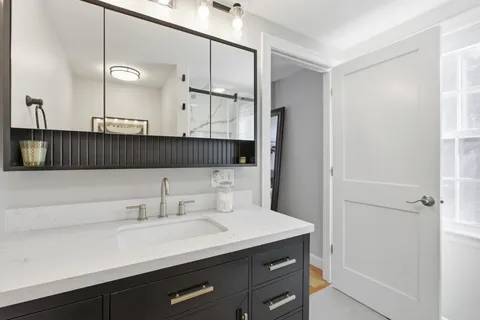 a bathroom with a sink a mirror and a vanity