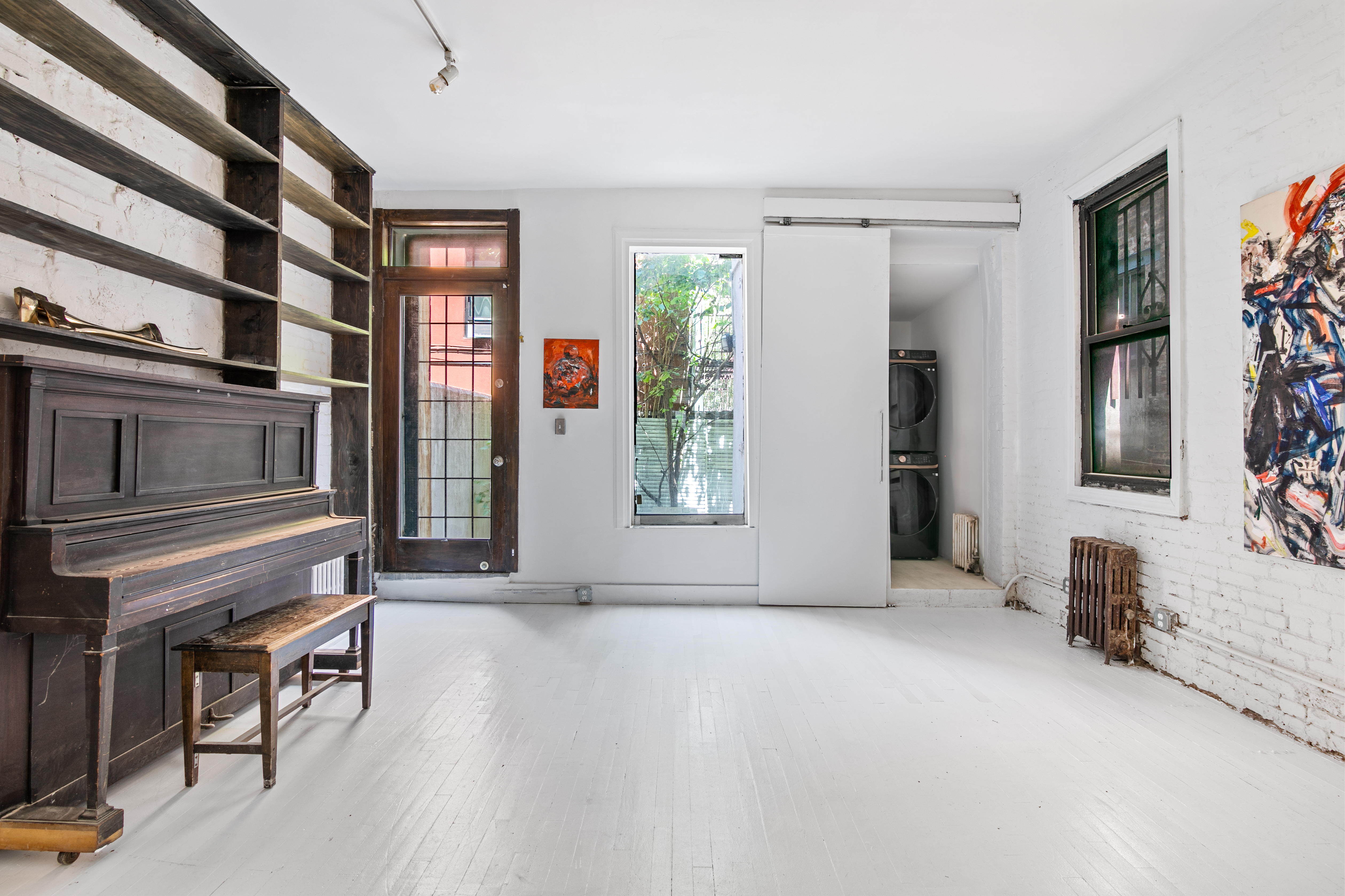 305 East 4th Street, Unit GARDEN Manhattan, NY 10009 - Photo 4 of 8 a view of an empty room with glass door and furniture
