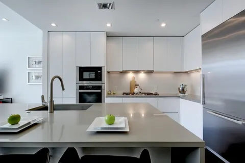 a kitchen with stainless steel appliances granite countertop a sink and a refrigerator