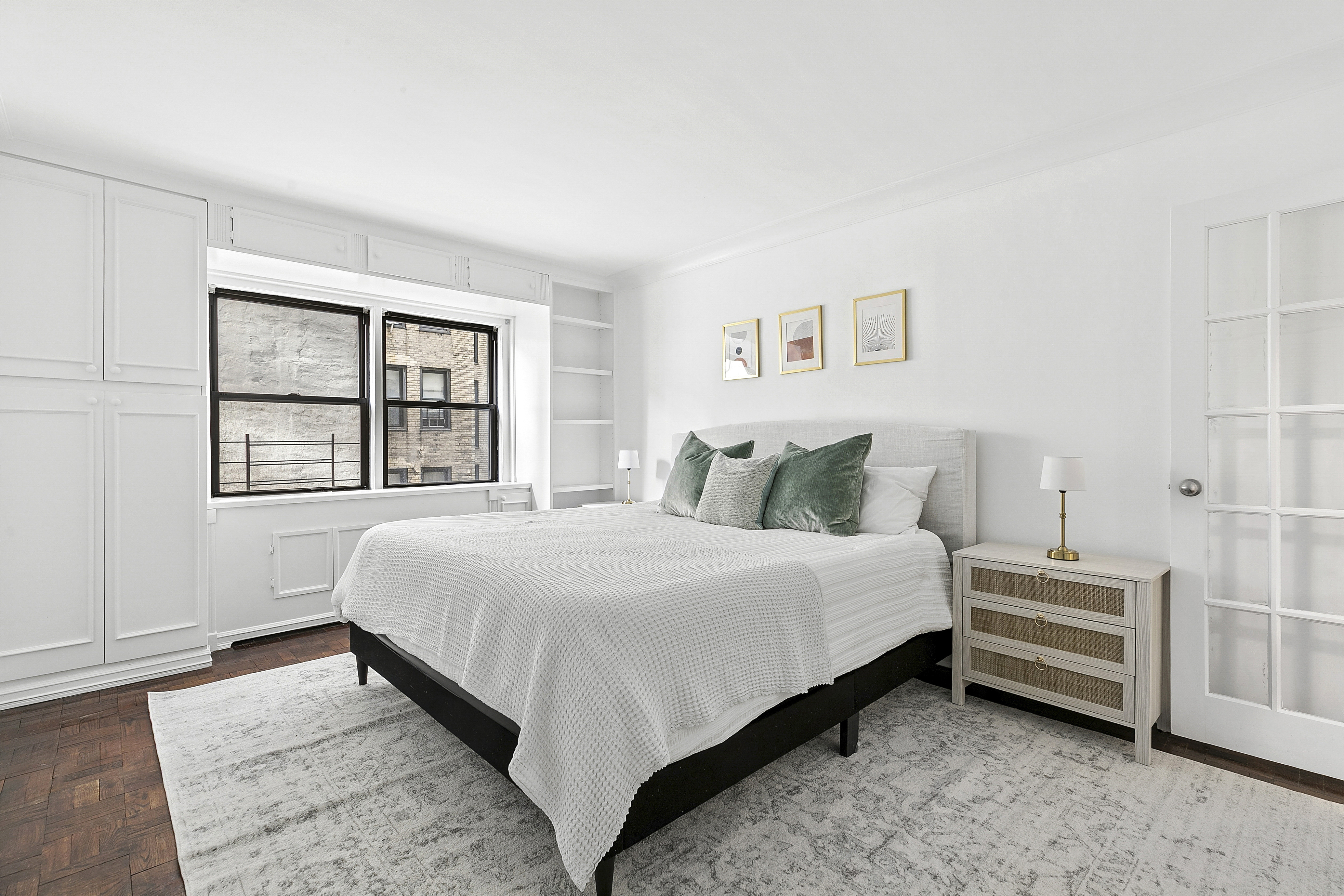 411 East 57th Street, Unit 4B Manhattan, NY 10022 - Photo 3 of 7 a bedroom with a bed lamp and a window