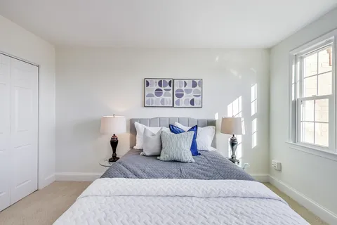 a spacious bedroom with a bed and a window