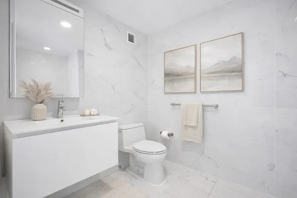 a bathroom with a toilet sink and mirror