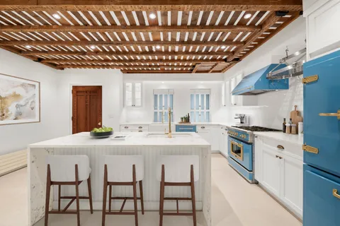 a kitchen with cabinets and chairs