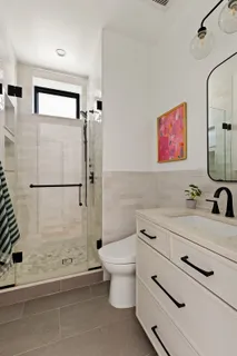 a bathroom with a sink a toilet and shower