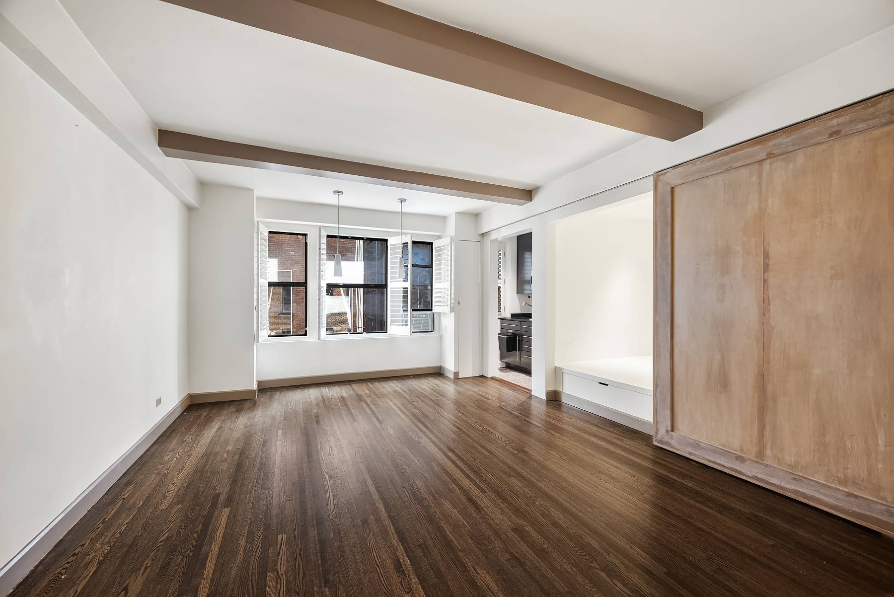 339 East 58th Street, Unit 3J Manhattan, NY 10022 - Photo 3 of 9 a view of an empty room with wooden floor and a window