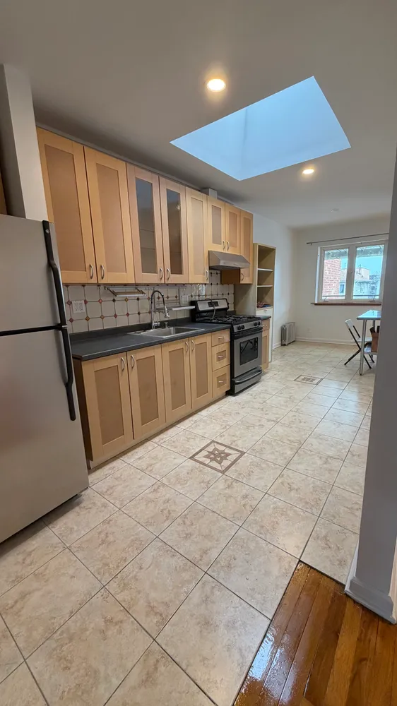 a kitchen with stainless steel appliances a stove a sink and a refrigerator