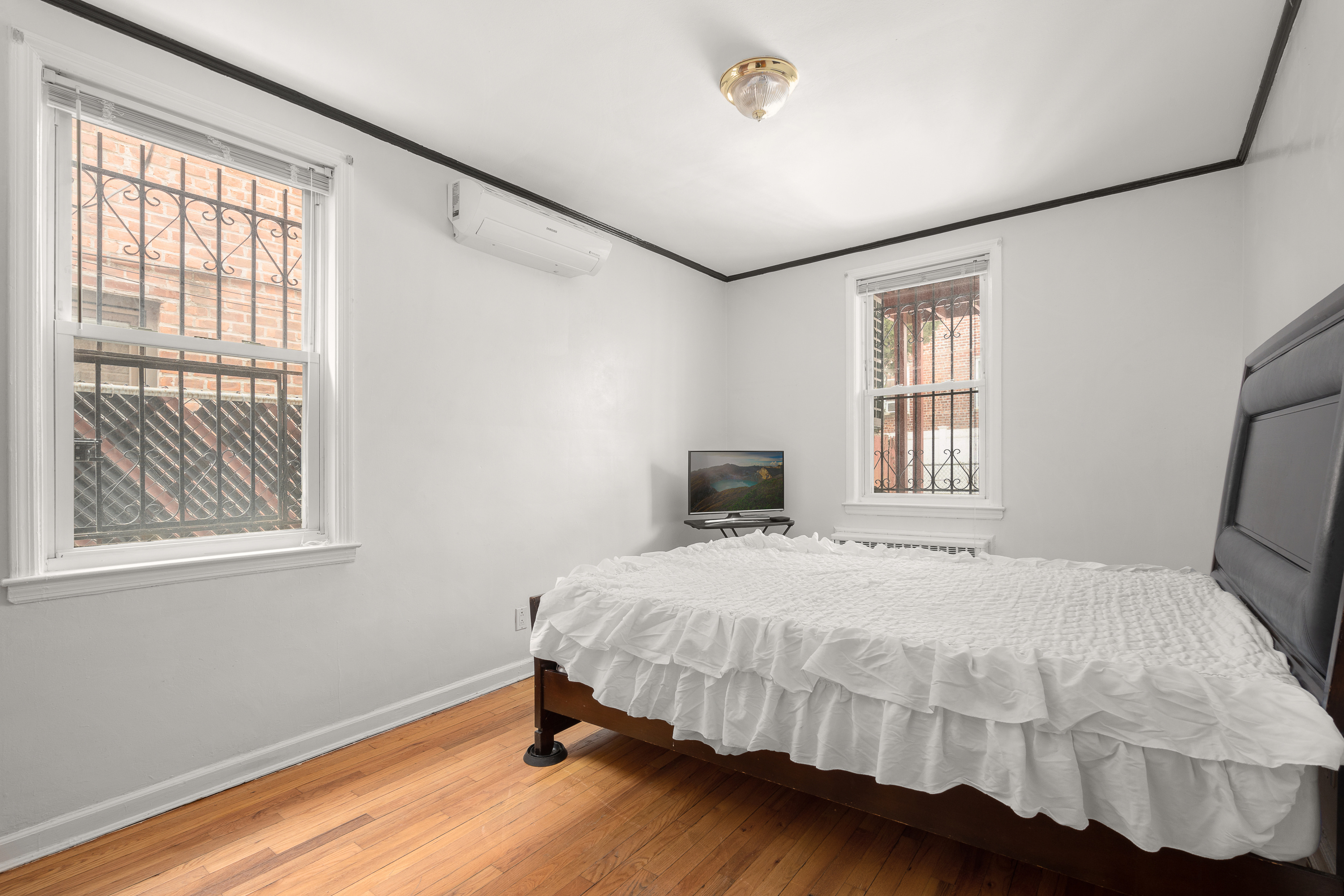 1268 East 52nd Street Brooklyn, NY 11234 - Photo 8 of 13 a bedroom with a bed and wooden floor
