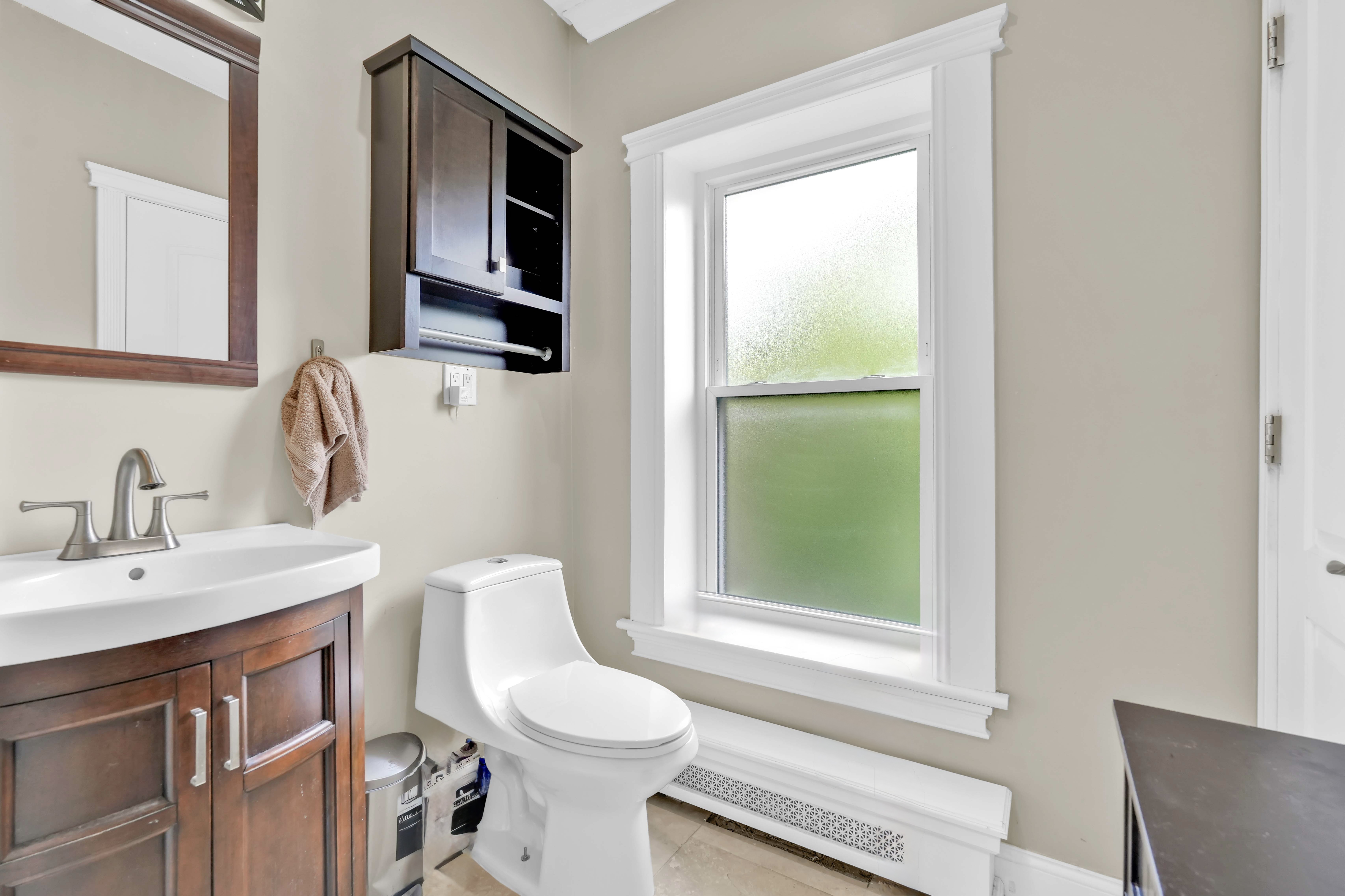 519 Monroe Street Brooklyn, NY 11221 - Photo 20 of 55 a bathroom with a toilet a sink a window and mirror