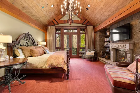 a bedroom with furniture a flat screen tv and a fireplace