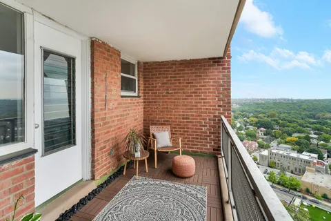 a view of a balcony with two chairs and a rug