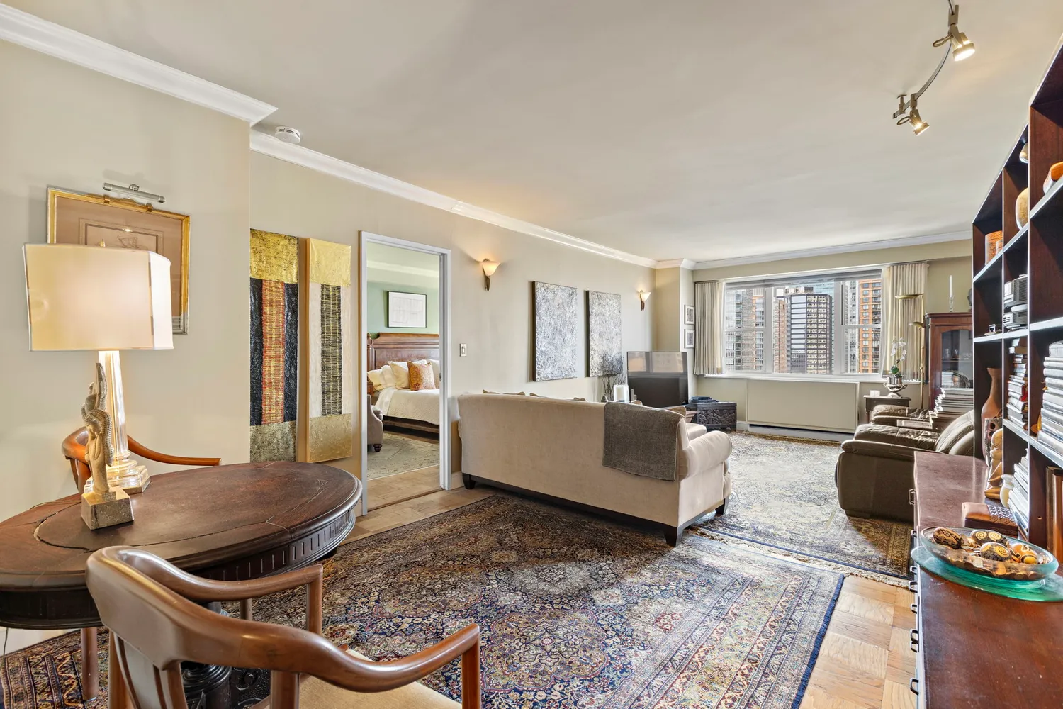 a living room with furniture a flat screen tv and a table