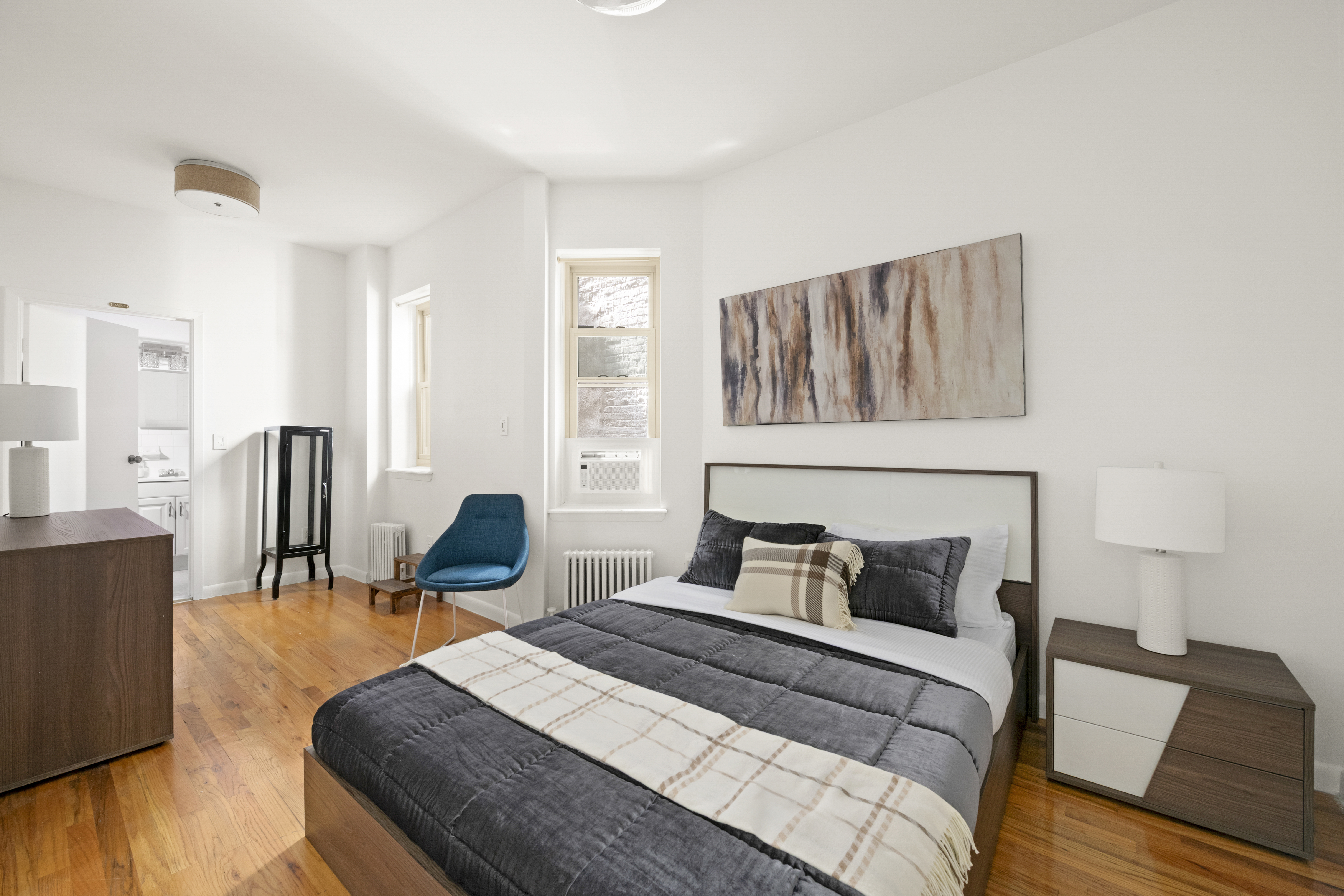 323 West 43rd Street, Unit 1R Manhattan, NY 10036 - Photo 4 of 8 a bedroom with furniture and wooden floor