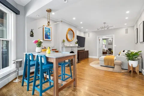 a living room with dining table and wooden floor