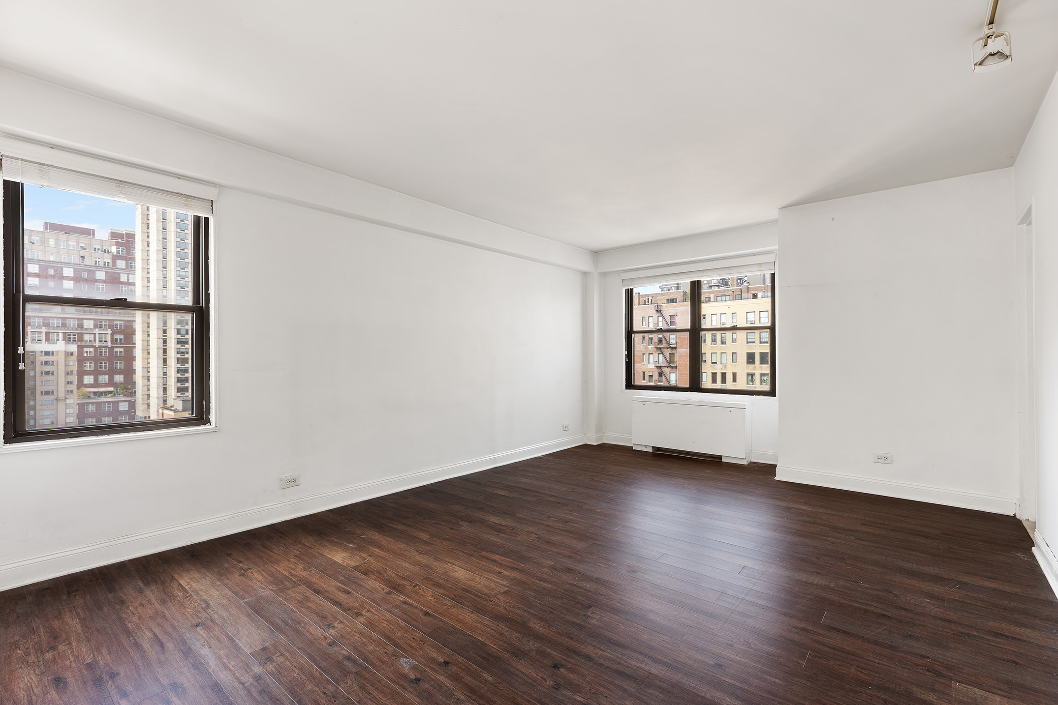 120 East 90th Street, Unit 16E Manhattan, NY 10128 - Photo 11 of 15 an empty room with wooden floor and windows