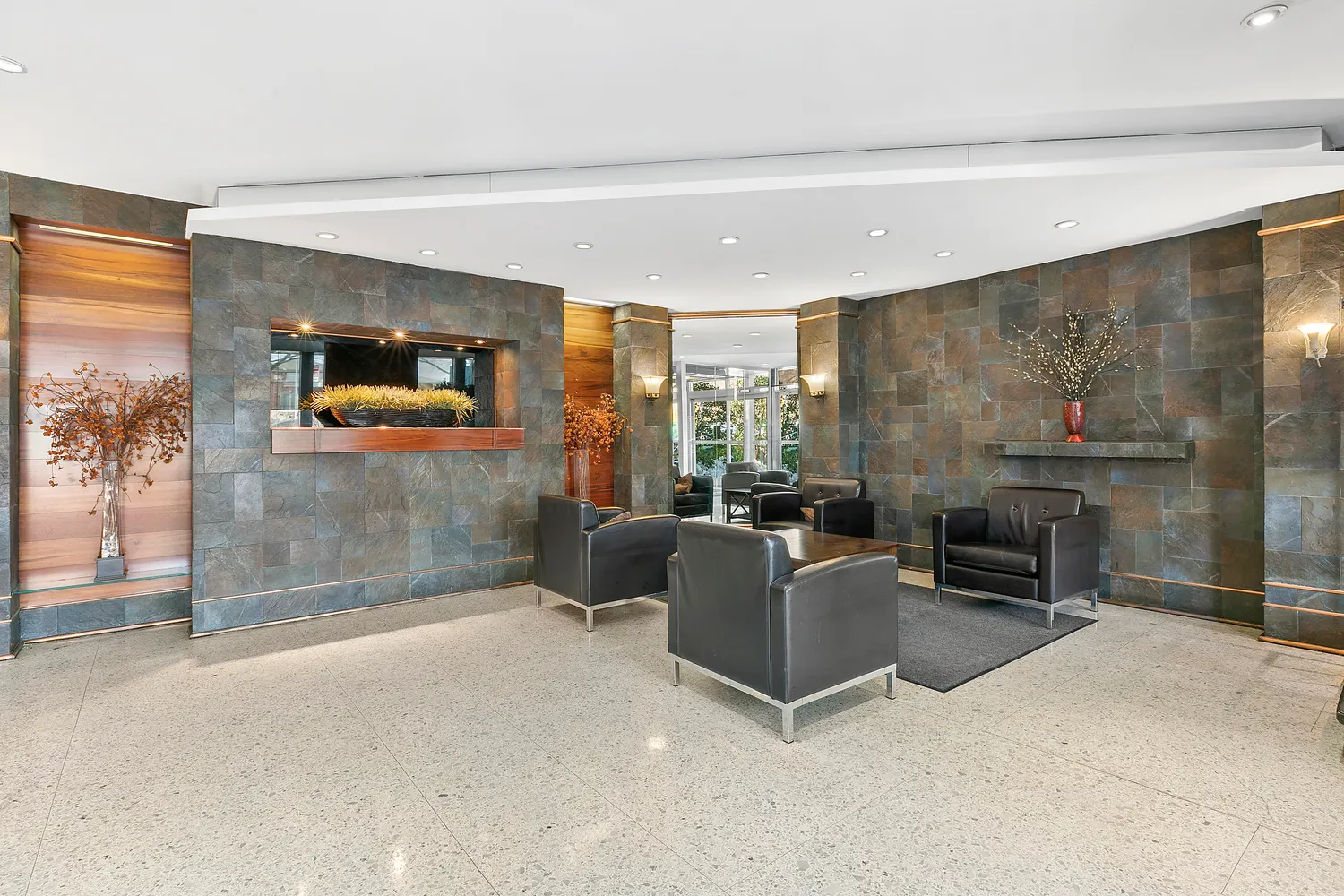 a living room with furniture a flat screen tv and a floor to ceiling window