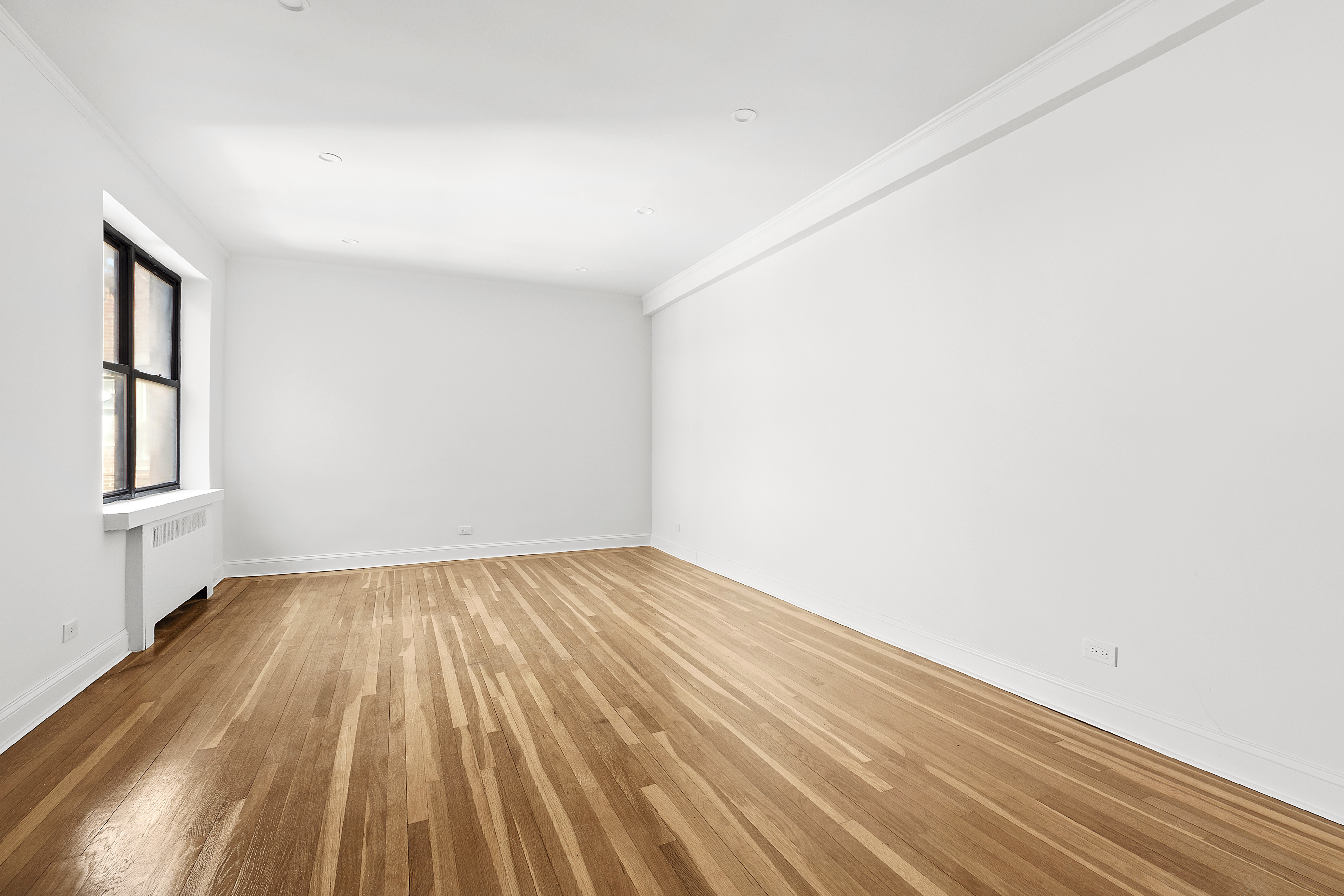 159-34 Riverside Drive West, Unit 7L90 Manhattan, NY 10032 - Photo 3 of 22 a view of an empty room with wooden floor and a window