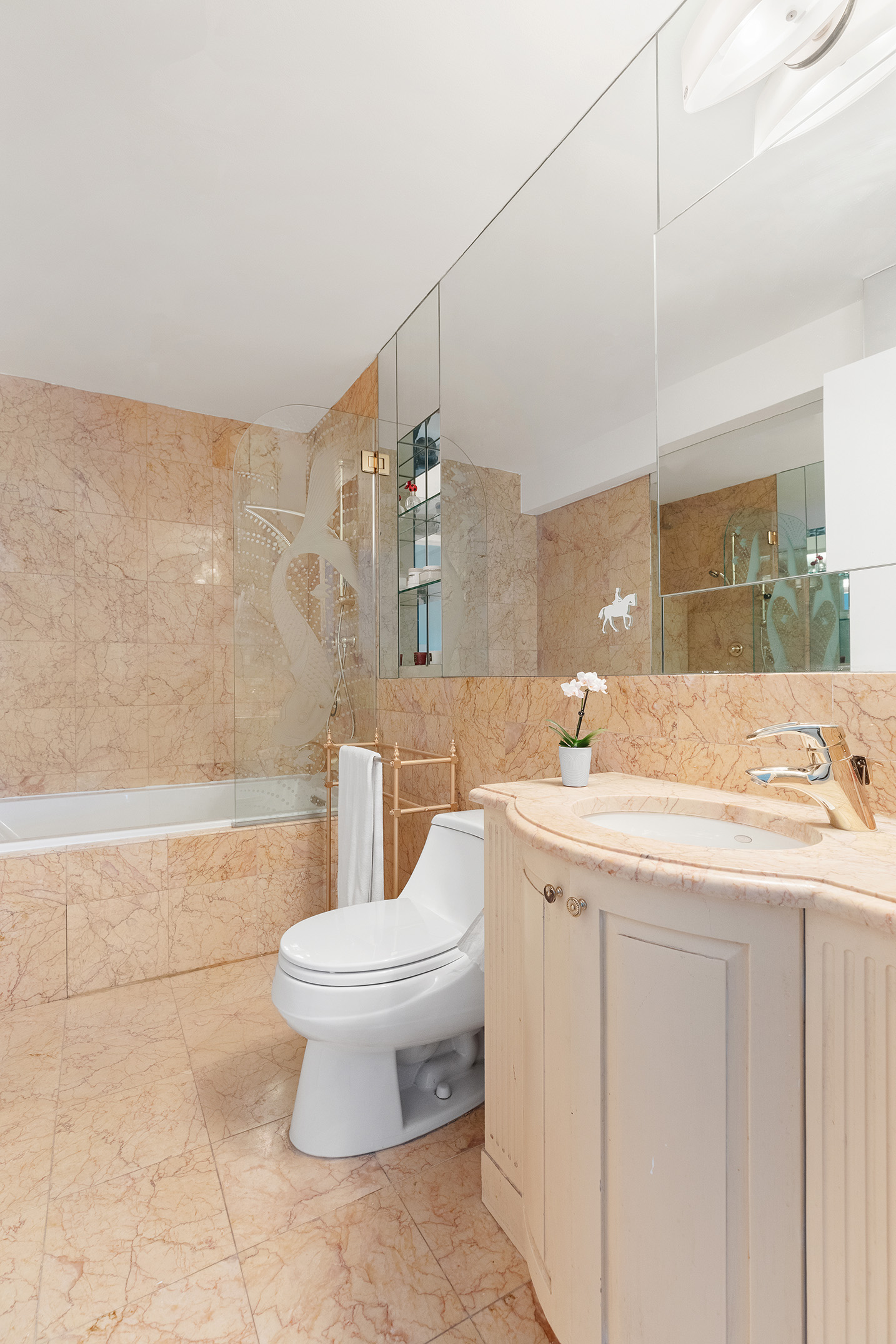 785 5th Avenue, Unit 5C Manhattan, NY 10022 - Photo 10 of 14 a bathroom with a sink a toilet and a mirror