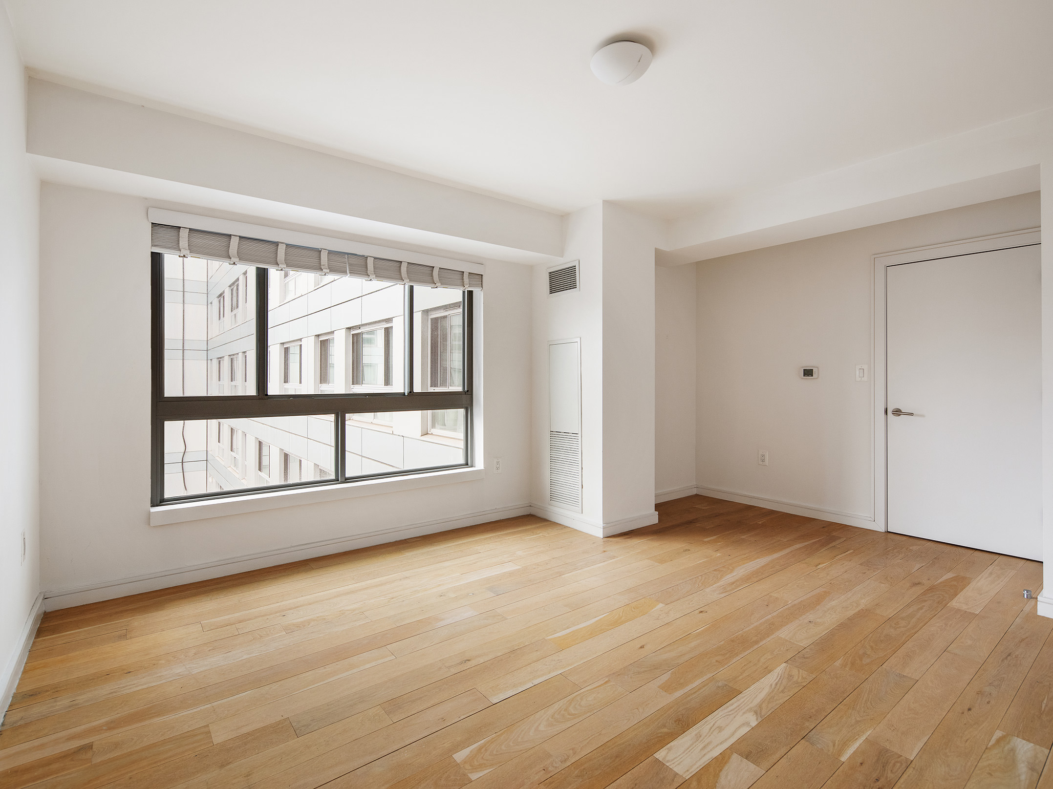 171 West 131st Street, Unit 519 Manhattan, NY 10027 - Photo 4 of 10 an empty room with wooden floor and windows