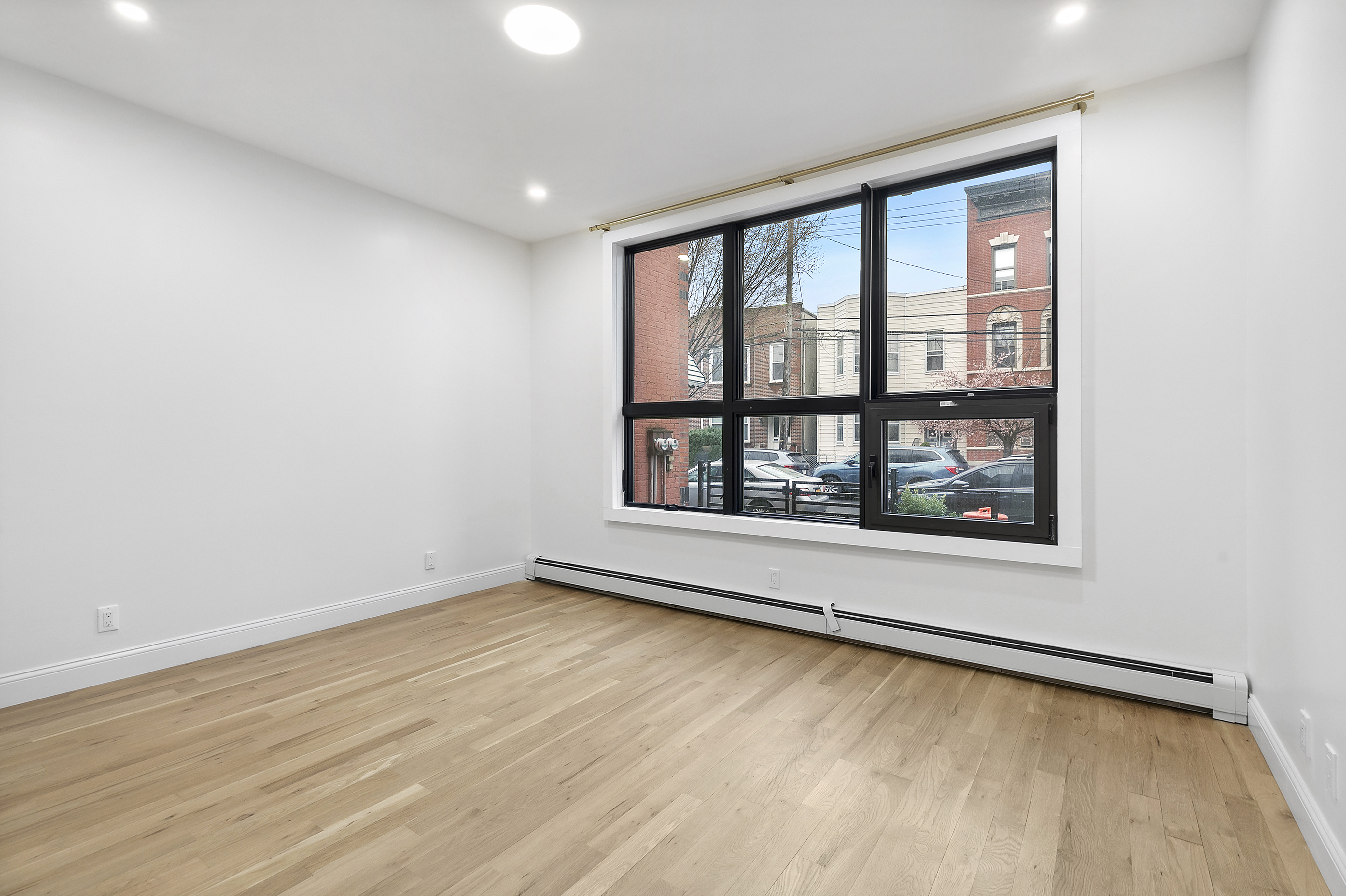 35-17 30th Street, Unit GARDEN Queens, NY 11106 - Photo 7 of 14 an empty room with wooden floor and windows