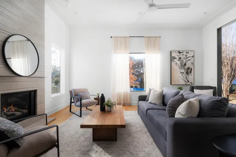 a living room with furniture a large window and a fireplace