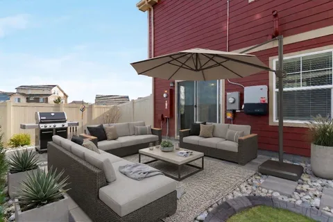 a view of swimming pool with lawn chairs and large trees