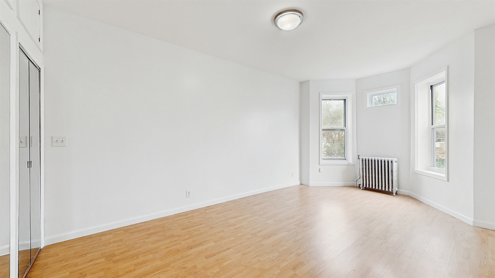 454 77th Street, Unit 3 Brooklyn, NY 11209 - Photo 19 of 25 a view of an empty room with wooden floor and a window