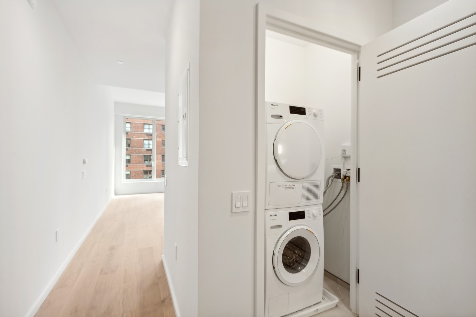 249 East 62nd Street, Unit 5C Manhattan, NY 10065 - Photo 5 of 9 a view of a hallway with washer and dryer