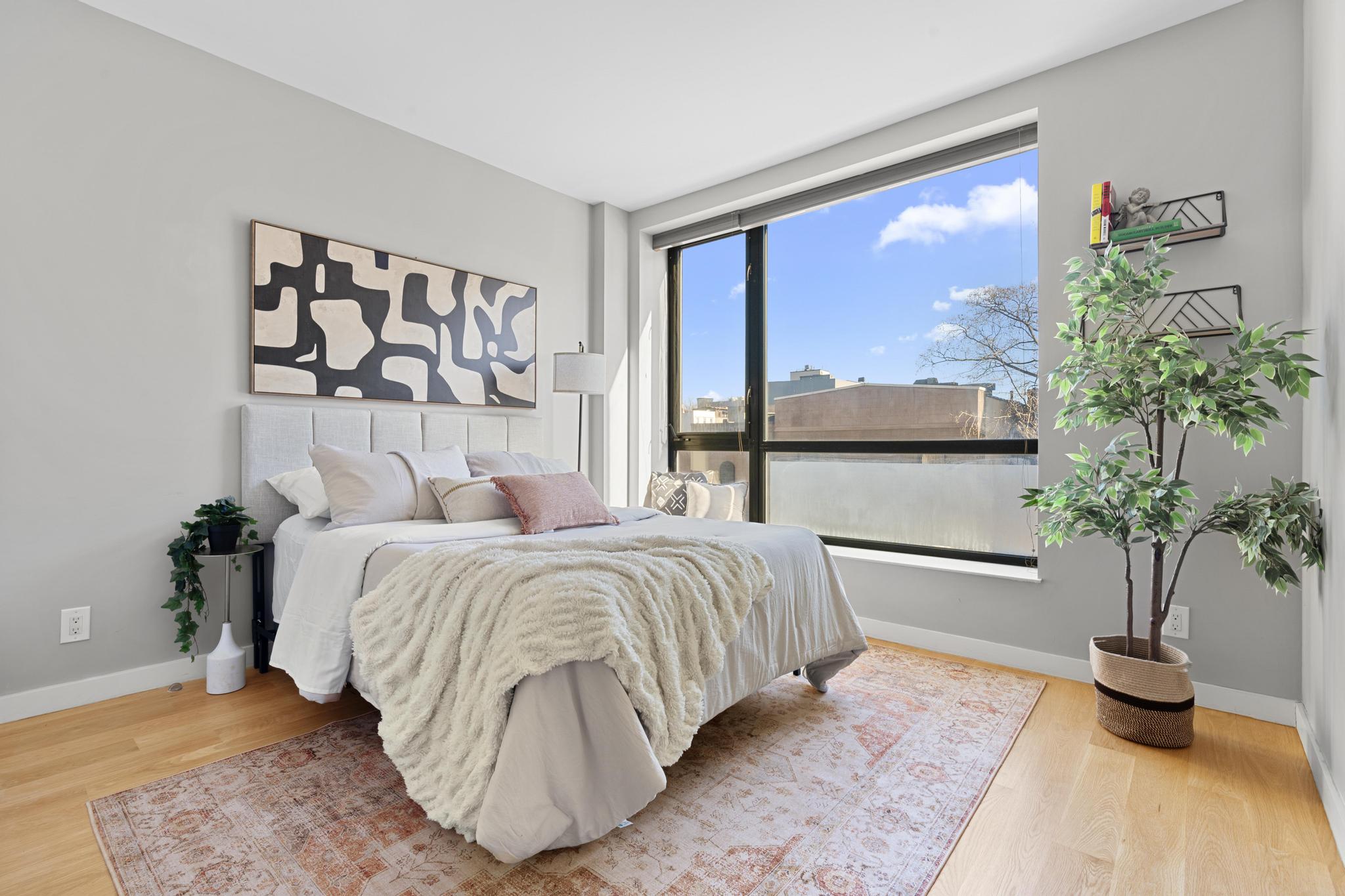 516 Classon Avenue, Unit 2B Brooklyn, NY 11238 - Photo 7 of 9 a bedroom with a large bed and a potted plant