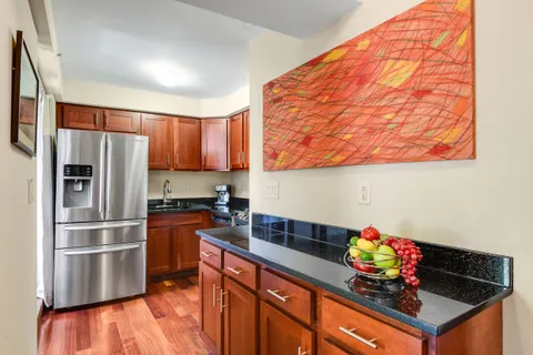 a kitchen with granite countertop a sink stainless steel appliances and cabinets