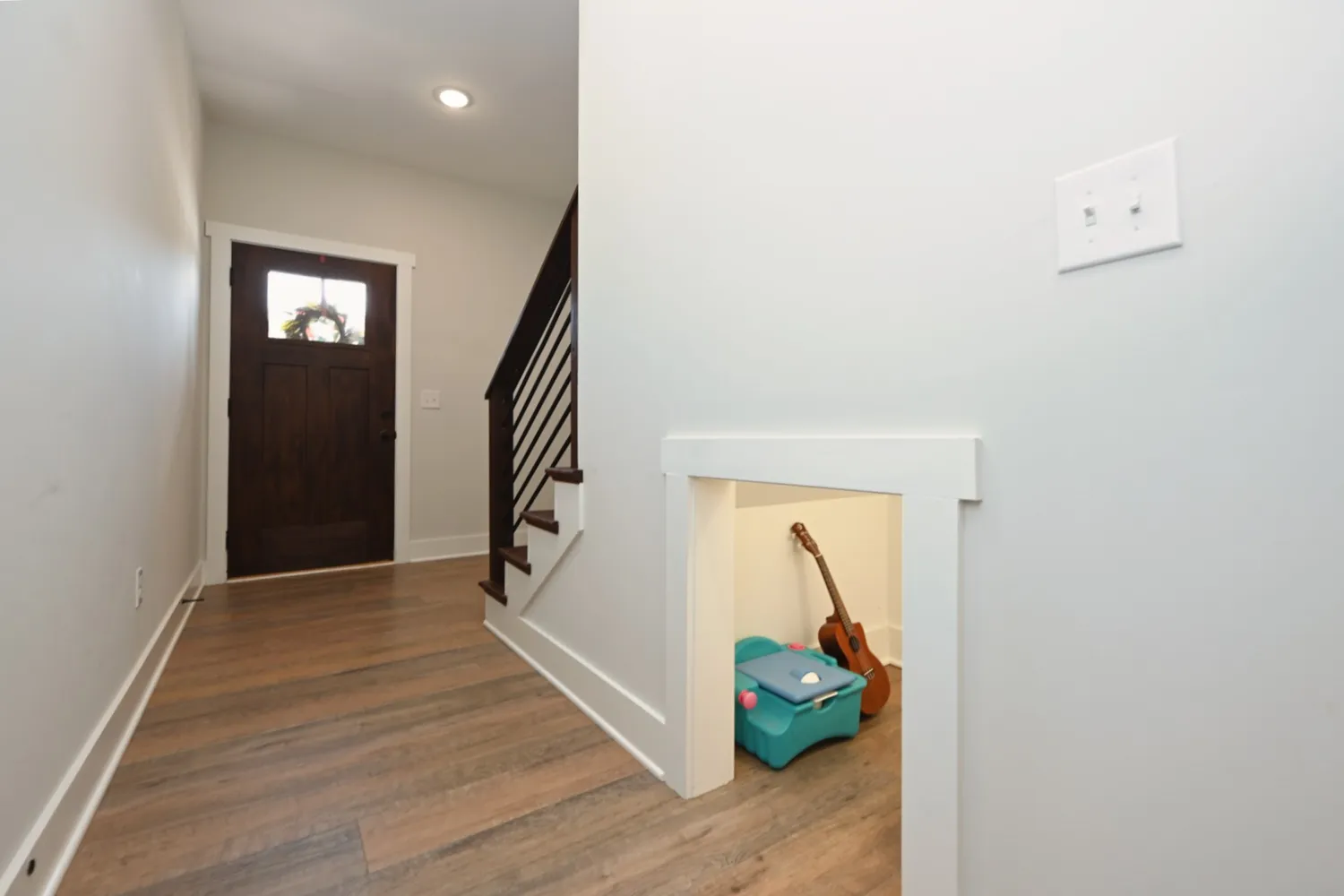 a view of hallway with stairs and wooden floor