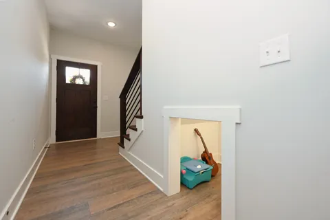 a view of hallway with stairs and wooden floor