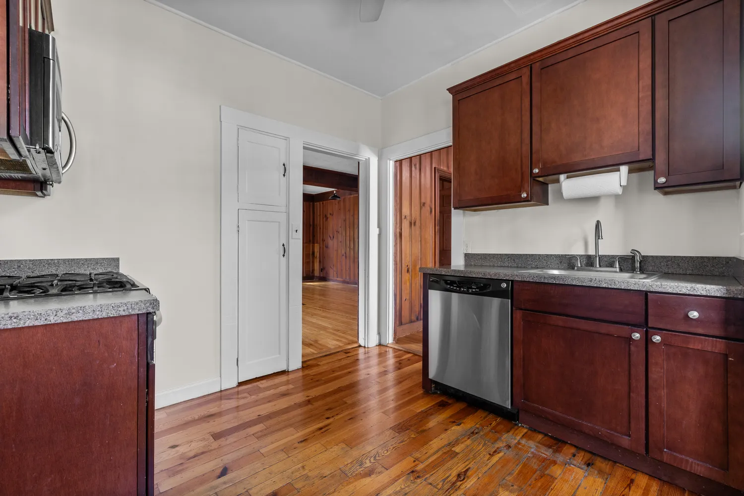 a kitchen with stainless steel appliances granite countertop a stove top oven a sink and dishwasher with wooden floor