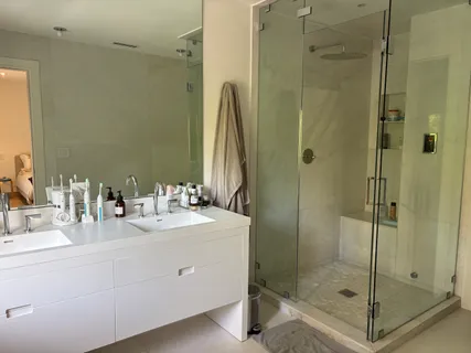 a bathroom with a shower sink and mirror