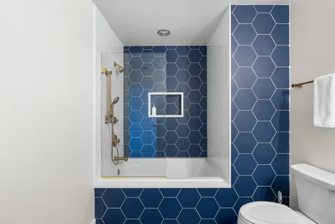 a bathroom with a granite countertop sink a toilet and shower