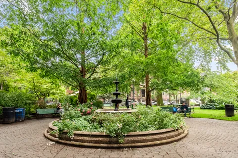 a view of a garden with large trees