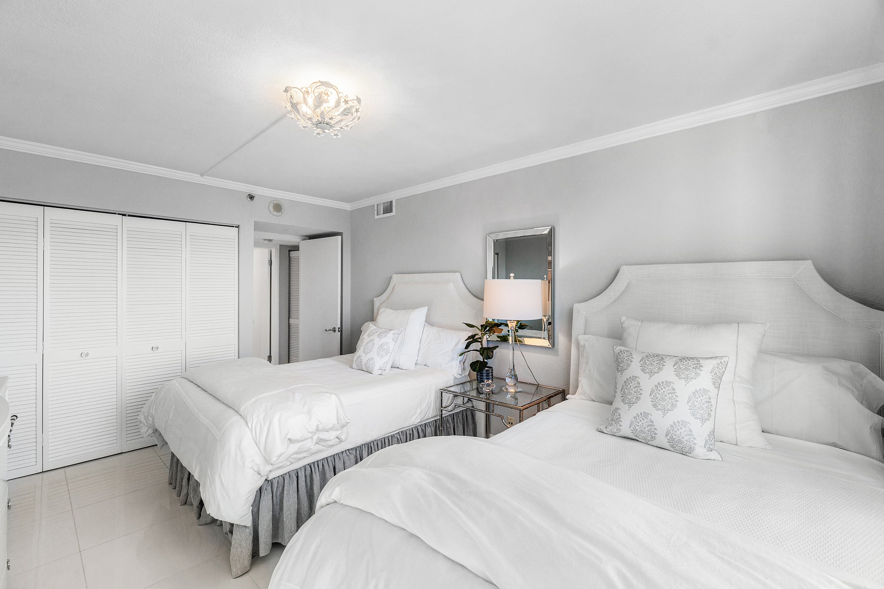 2003 North Ocean Boulevard, Unit 305 Boca Raton, FL 33431 - Photo 36 of 56 a bedroom with a bed and a chandelier