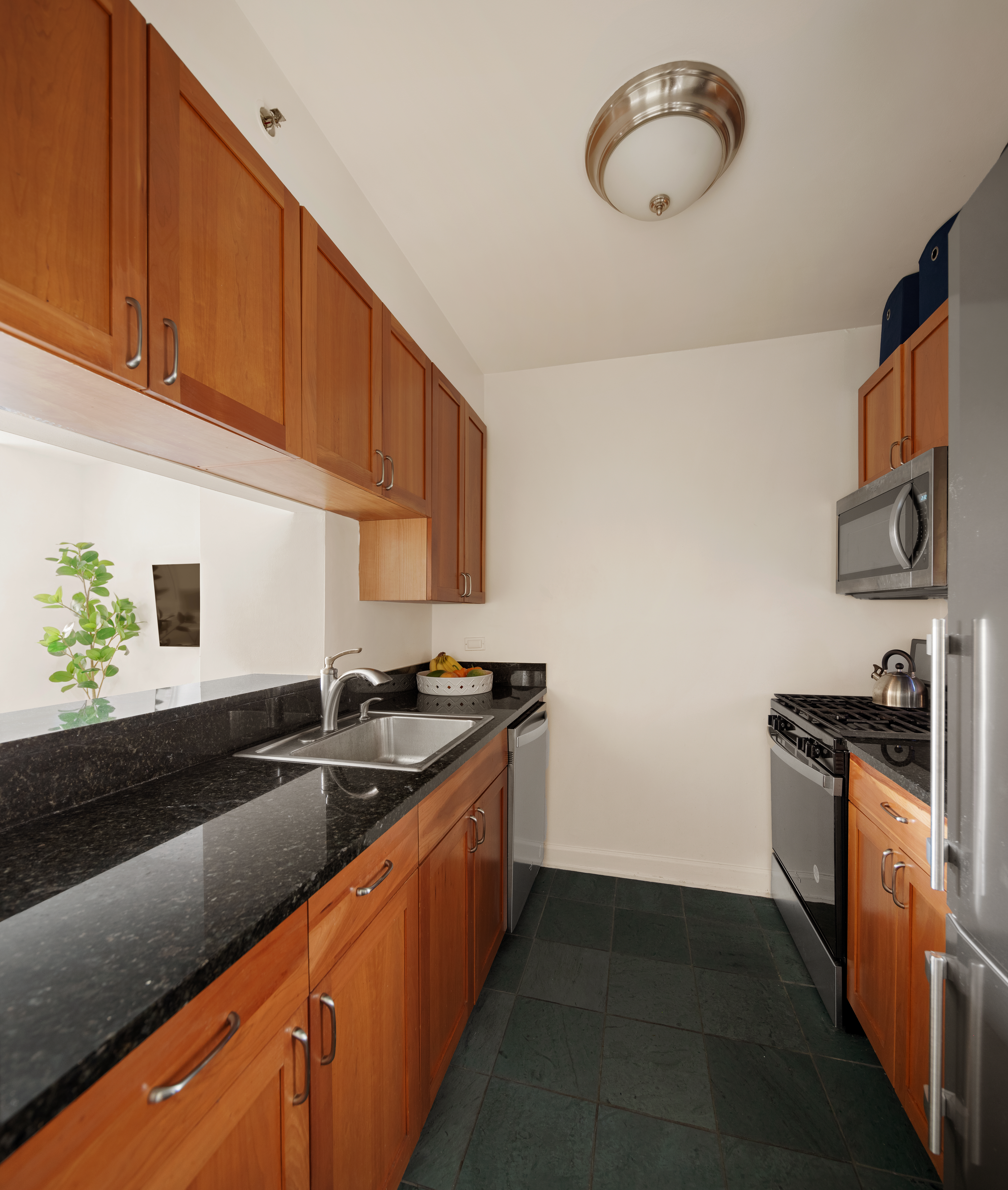 20 River Terrace, Unit 6Q Manhattan, NY 10282 - Photo 4 of 20 a kitchen with granite countertop cabinets a sink and a stove